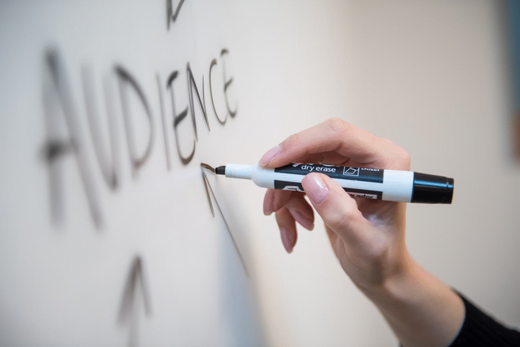 How to Sell Merchandise Online in 2025: A Creator’s Guide 1 Person writing audience on a whiteboard while discussing how to sell merchandise online.
