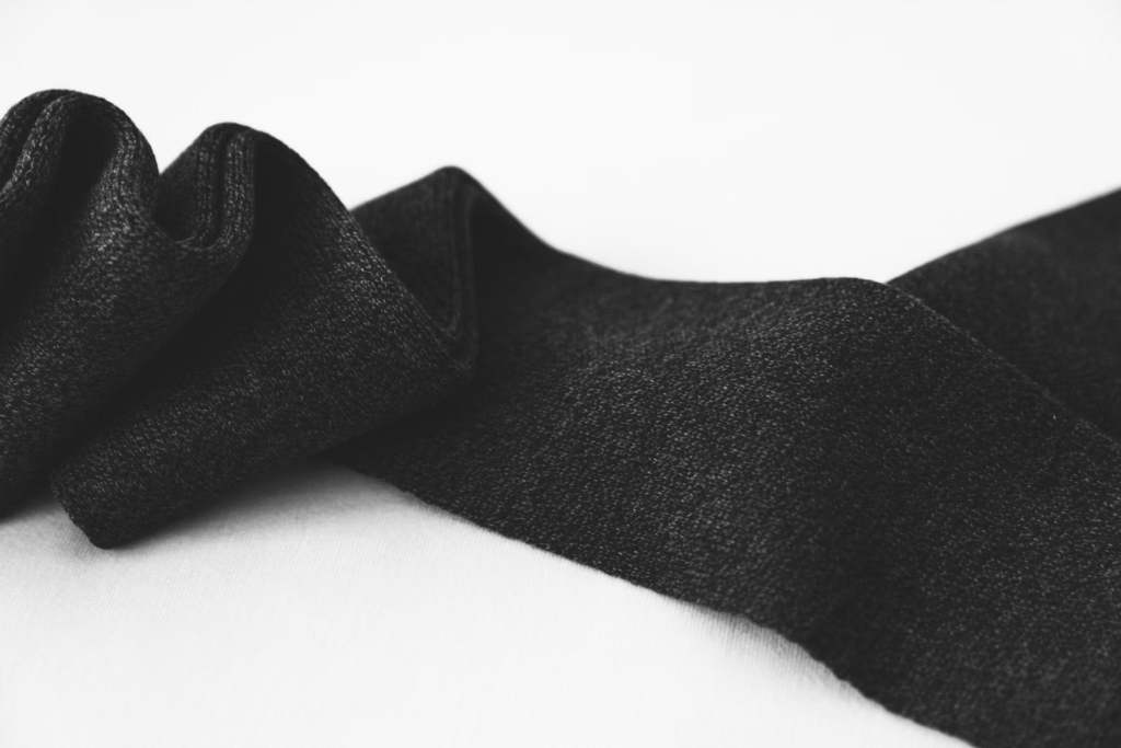 Black cashmere fabric laid out on a white background, one of the warmest fabrics for winter.