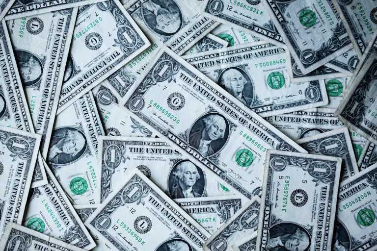 A pile of one dollar bills showing off how much does it cost to start a clothing brand in 2025?