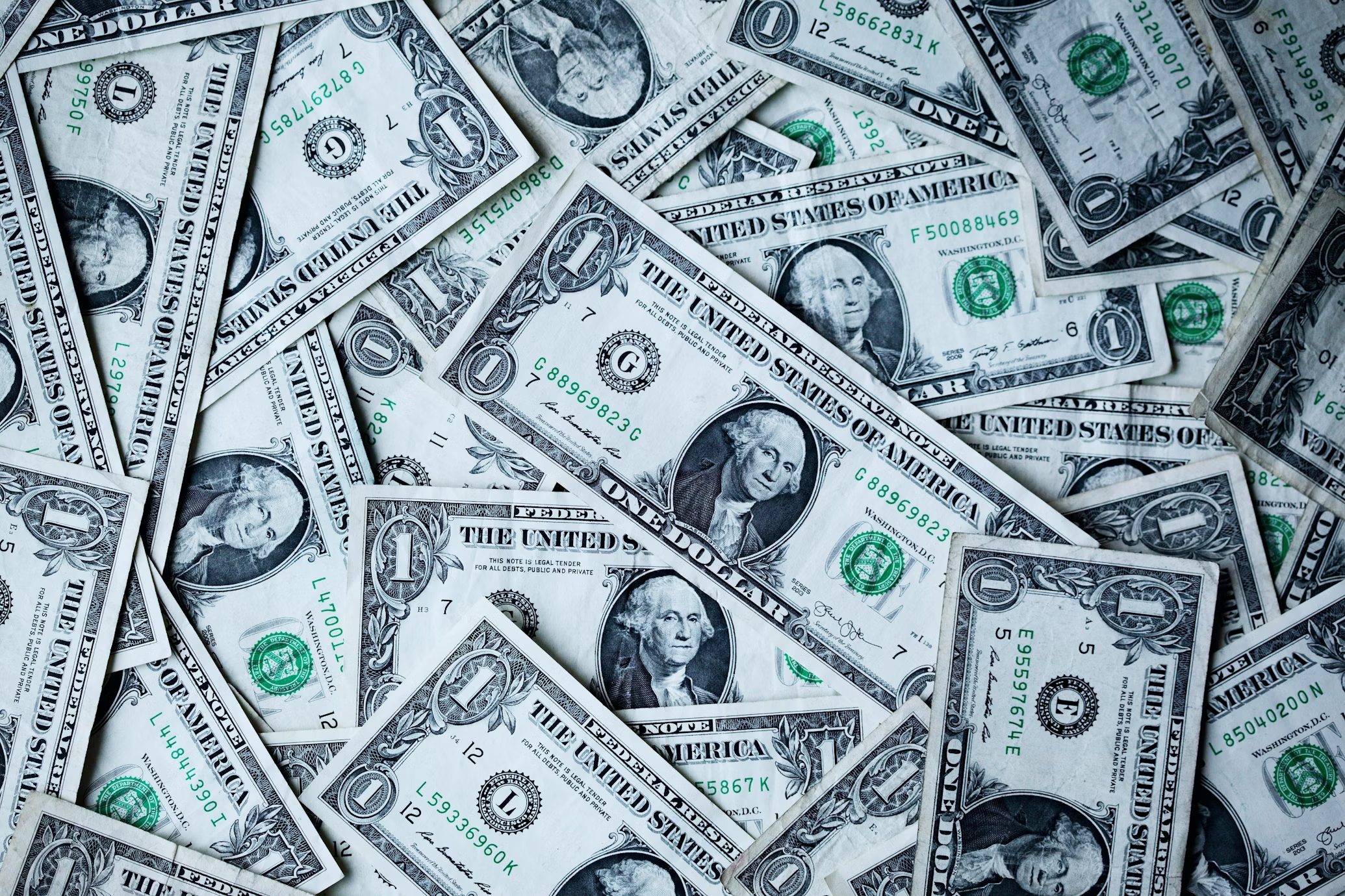 A pile of one dollar bills showing off how much does it cost to start a clothing brand in 2025?