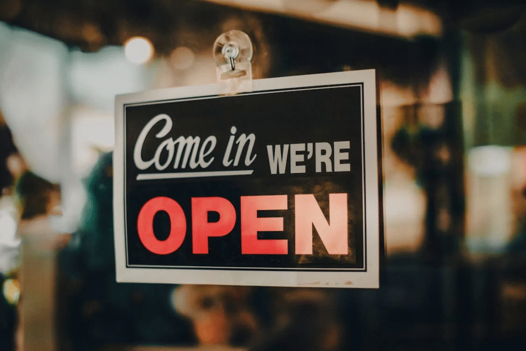 7 Trendy Restaurant Merchandise Ideas Customers Will Love 1 A restaurant sign saying "Come in, we're open" also showcasing restaurant merchandise.