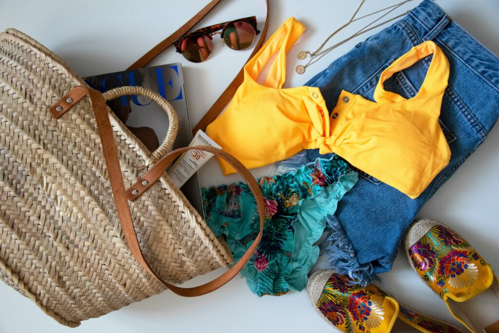 A set of beach clothing, sunglasses and a bag showing fabrics for summer heat.