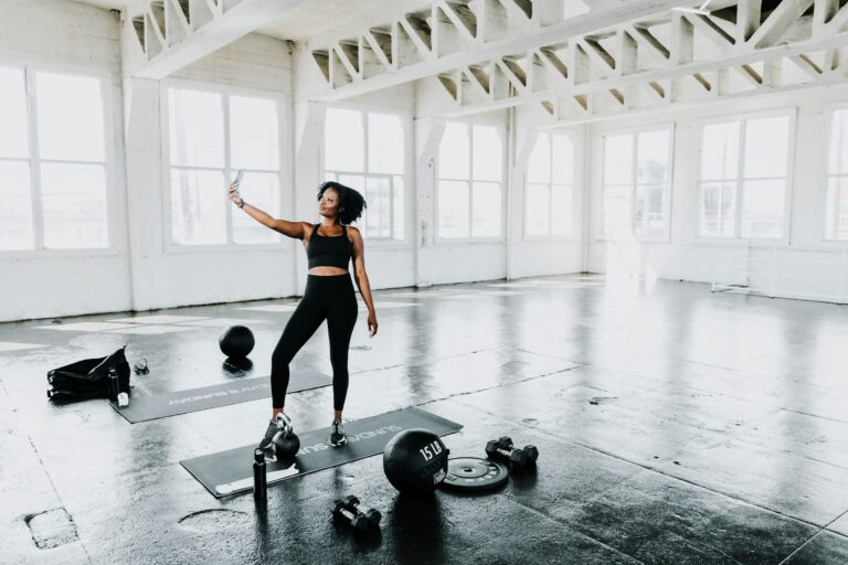 A woman wearing a custom dri-fit shirt in the gym while taking pics of herself.