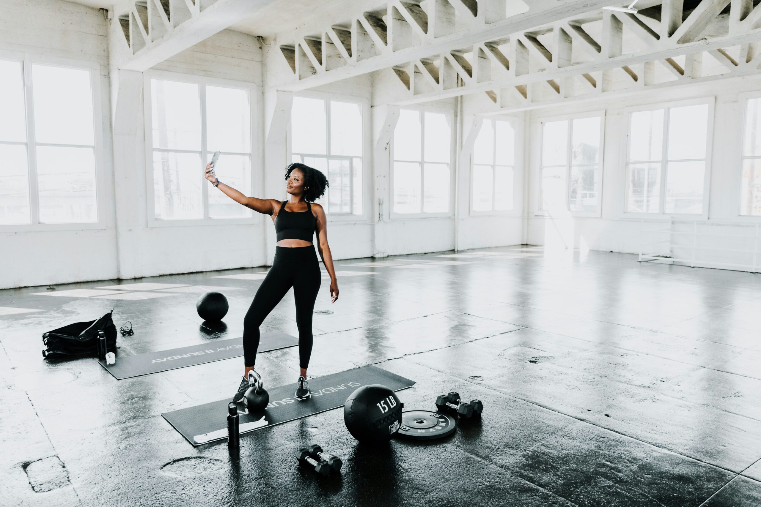 A woman wearing a custom dri-fit shirt in the gym while taking pics of herself.